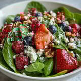 Fresh baby spinach and mixed berries tossed with creamy goat cheese and crunchy walnuts in a Spinach and Berry Salad Bowl, drizzled with tangy balsamic vinaigrette.