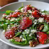 Spring Dinner Party Strawberry Arugula Salad with Balsamic Glaze - A colorful mix of fresh strawberries, peppery arugula, creamy goat cheese, and toasted nuts drizzled with tangy balsamic reduction.