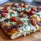 Golden cottage cheese flatbread topped with savory pizza sauce, cherry tomatoes, and olives, perfect for a quick dinner.  