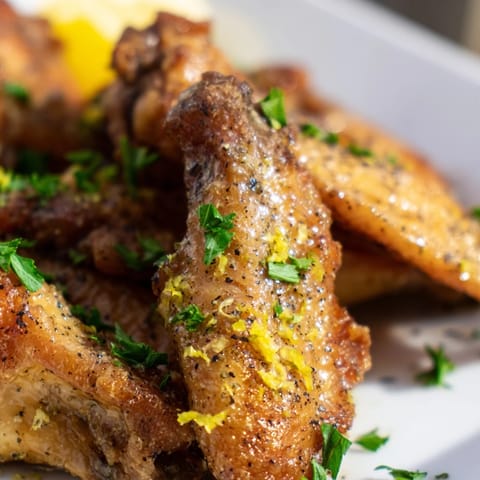 Crispy oven-baked Lemon Pepper Wings tossed in tangy butter sauce, paired with cool ranch and crunchy celery sticks.