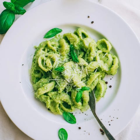 Steaming Creamy Avocado Pesto Mac with tender pasta coated in a vibrant green sauce, ready to eat.