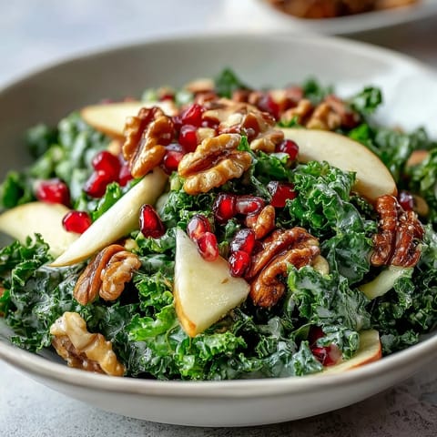 Freshly massaged kale tossed with crisp apple slices, juicy pomegranate seeds, and chopped walnuts, all lightly coated in a sweet and tangy apple cider vinaigrette.