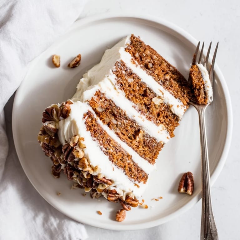 Freshly baked Hummingbird Cake garnished with chopped pecans, ready to enjoy with a cup of coffee.