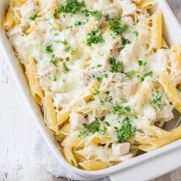 Penne pasta and tender chicken coated in creamy Alfredo sauce, baked to golden perfection in a casserole.
