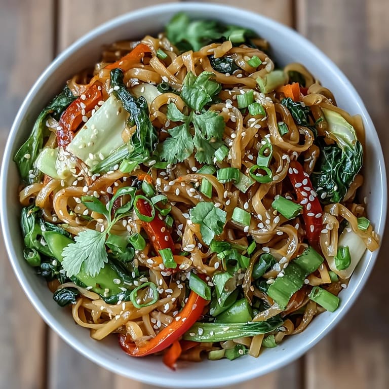 Quick low-carb Asian fusion Shirataki Noodle Bowl featuring julienned carrots and snow peas tossed in savory sauce.