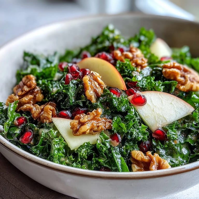A vibrant Kale and Pomegranate Bowl served as a hearty vegetarian salad, garnished with toasted walnuts for a satisfying crunch and rich, nutty flavor.
