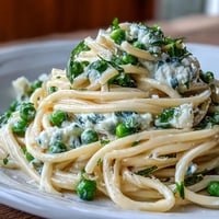 Creamy Lemon Ricotta Pasta with vibrant green peas and fresh mint.